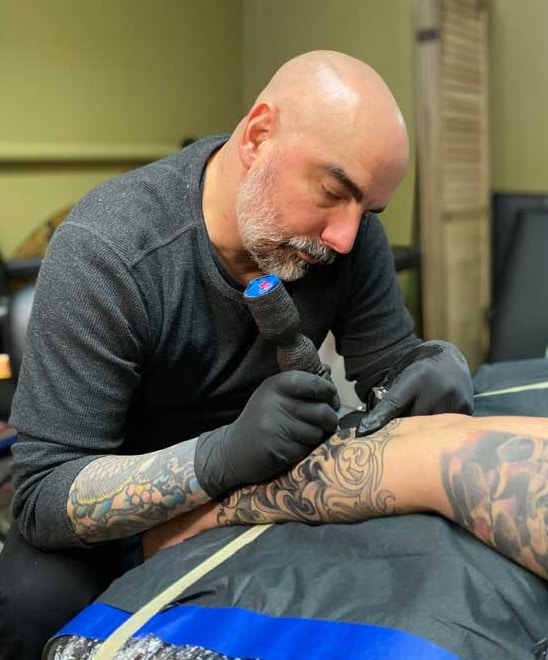 Bobby Chichester tattooing a client