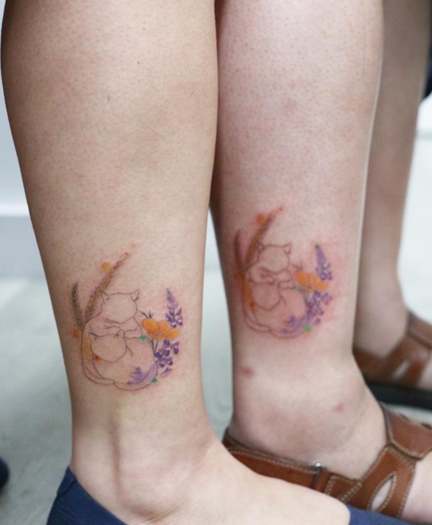 Matching cat tattoos symbolizing sisterhood